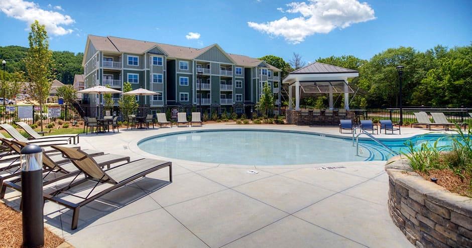 a swimming pool with chairs and a building in the background  at Lullwater at Big Ridge, Hixson, Tennessee
