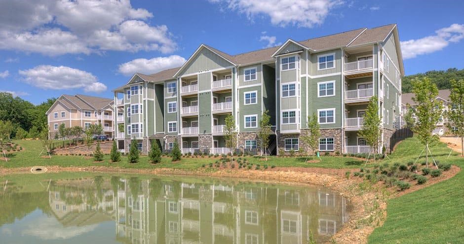 an apartment building with a pond in front of it  at Lullwater at Big Ridge, Hixson