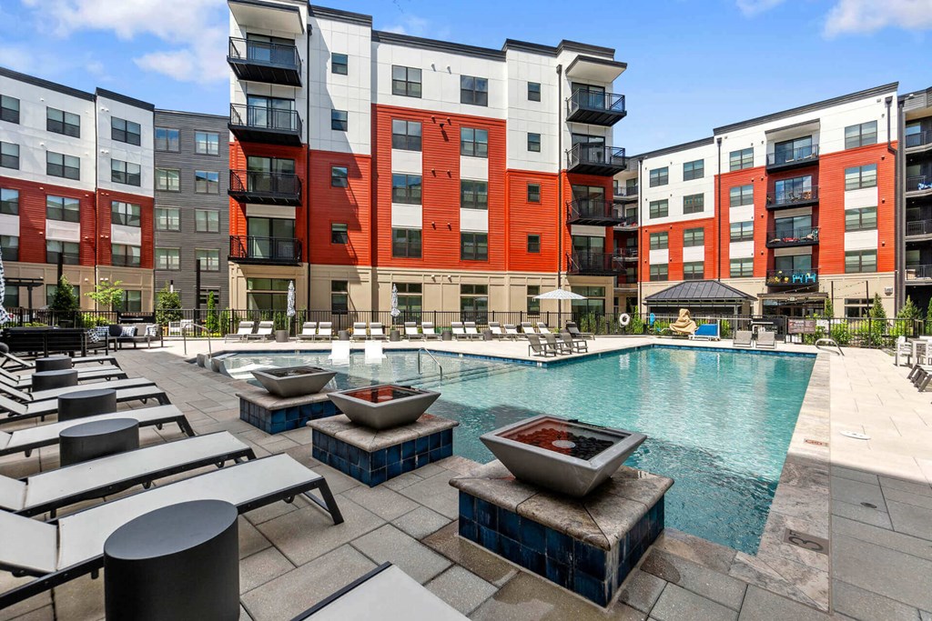an outdoor pool with lounge chairs and fire pits at the bradley braddock road station at Tapestry West, Richmond Virginia