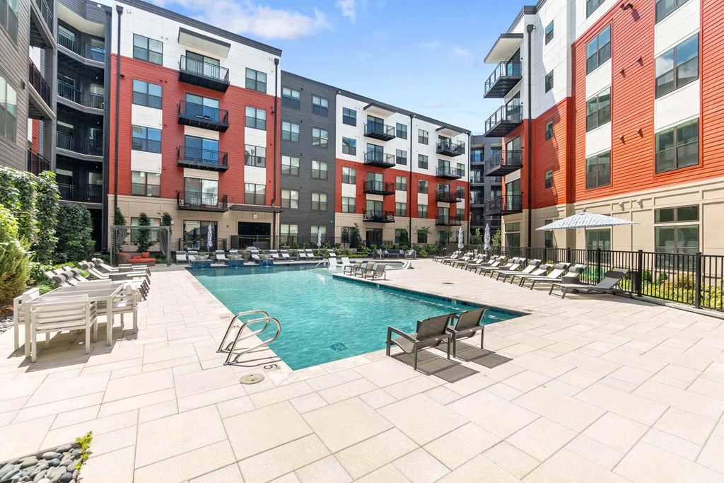an outdoor pool with lounge chairs and tables at the bradley braddock road station apartments at Tapestry West, Virginia, 23230