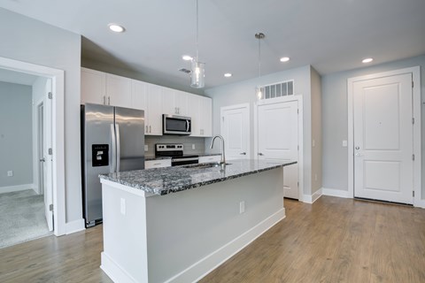 A kitchen with a granite countertop and stainless steel appliances.