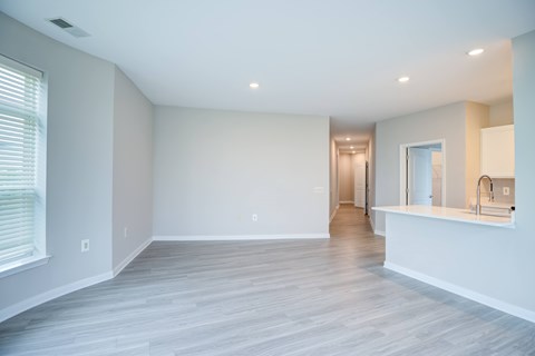 A spacious room with a window on the left and a door on the right.