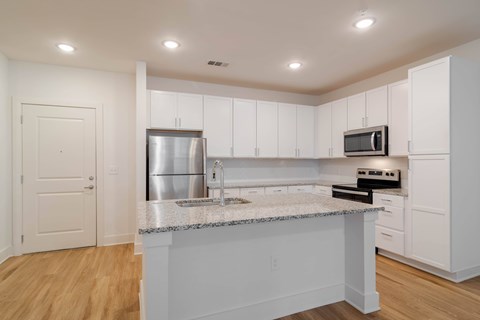 A kitchen with white cabinets and a granite countertop.