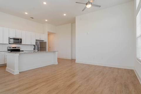 A kitchen with white cabinets and a wooden floor.