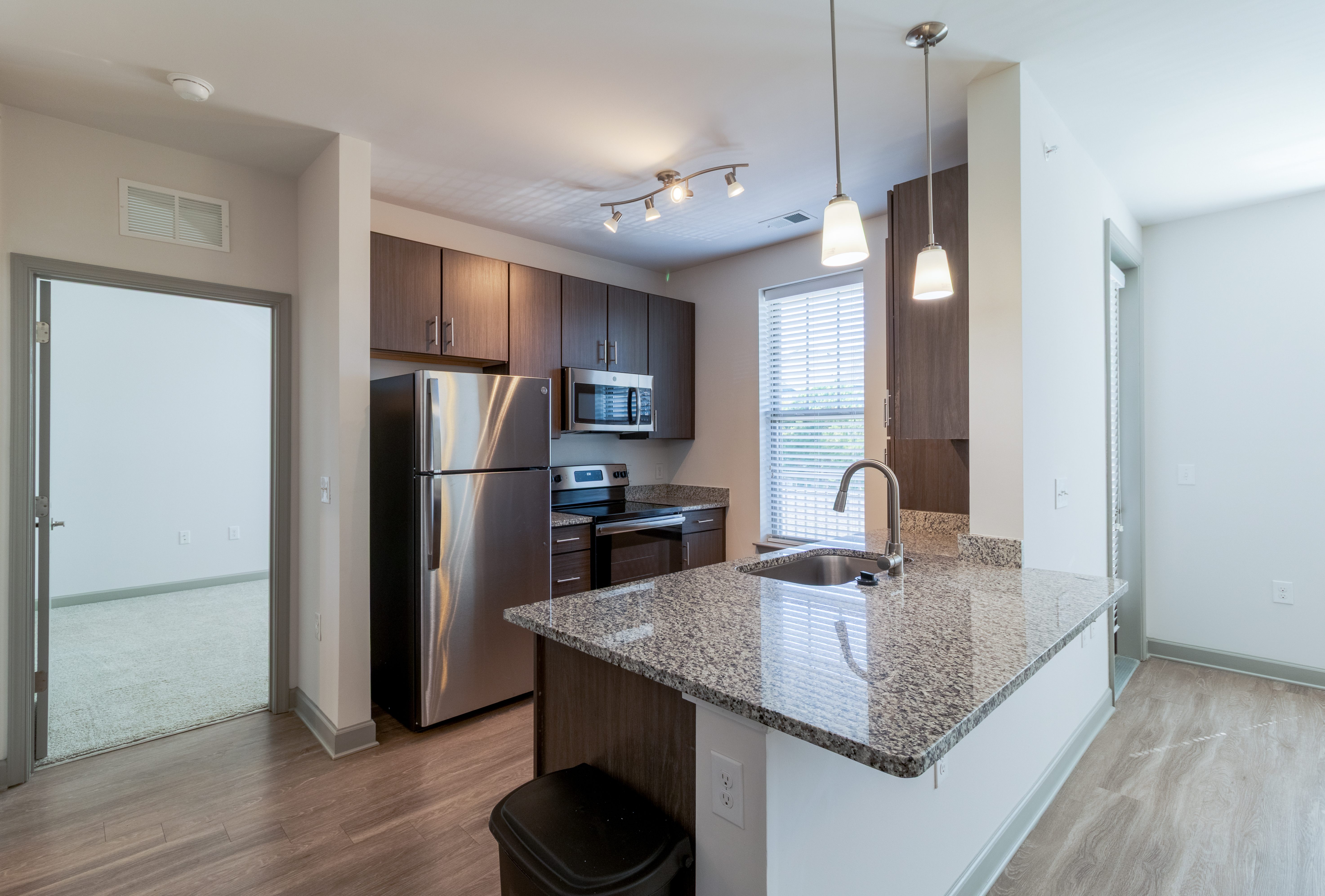 A kitchen with a granite countertop and stainless steel appliances.