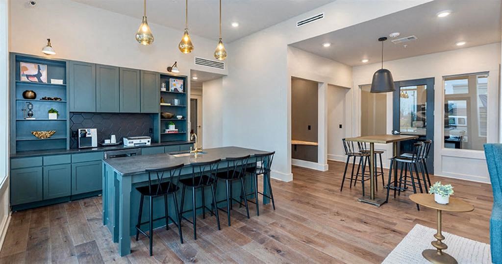 a kitchen and living room with a blue table and chairs at Livingston Flats Apartments, Chesterfield, Virginia