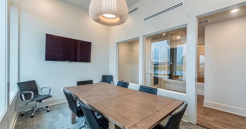 a conference room with a wooden table and black chairs at Livingston Flats Apartments, Chesterfield, VA
