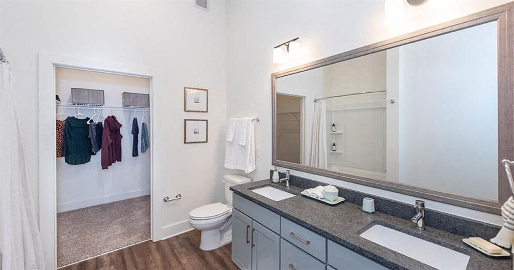 a bathroom with a large mirror and a toilet at  Livingston Flats Apartments, Virginia