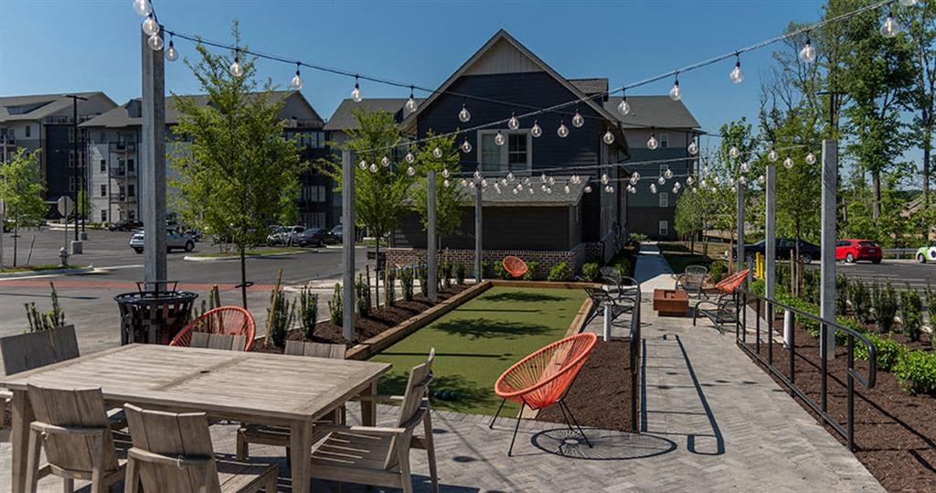 a patio with tables and chairs in front of a building at  Livingston Flats Apartments, Virginia