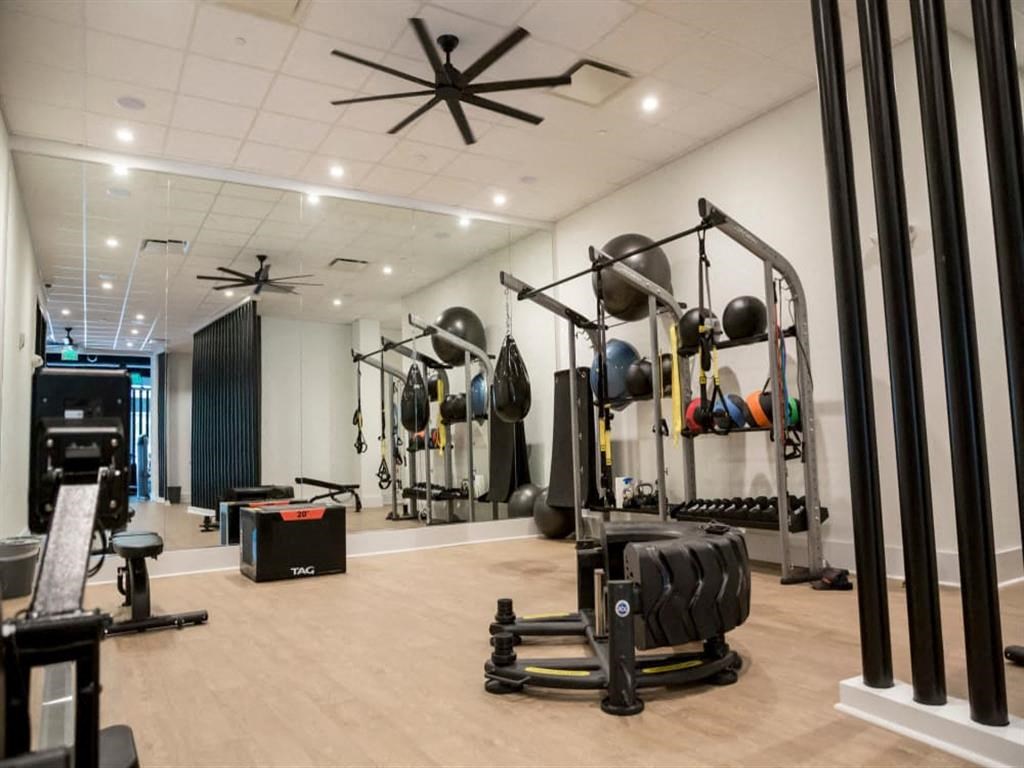 a gym with weights and other exercise equipment at Flats at West Broad Village, Virginia