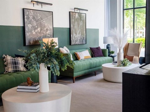 a living room with green couches and a white table