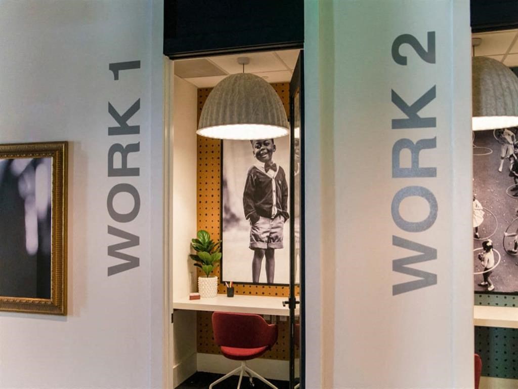 a desk with a lamp and a picture on the wall at Flats at West Broad Village, Glen Allen, VA