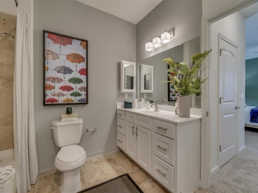 a bathroom with a toilet a sink and a mirror at Flats at West Broad Village, Glen Allen Virginia