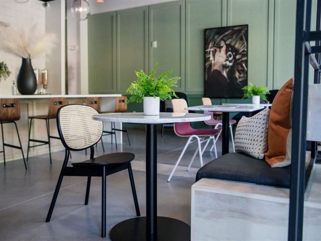 a table and chairs in a room with a couch and a painting on the wall at Flats at West Broad Village, Glen Allen, 23060