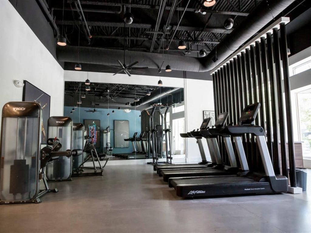 a gym with treadmills and other exercise equipment at Flats at West Broad Village, Glen Allen