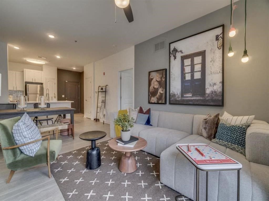 a living room with a couch a table and a chair at Flats at West Broad Village, Glen Allen