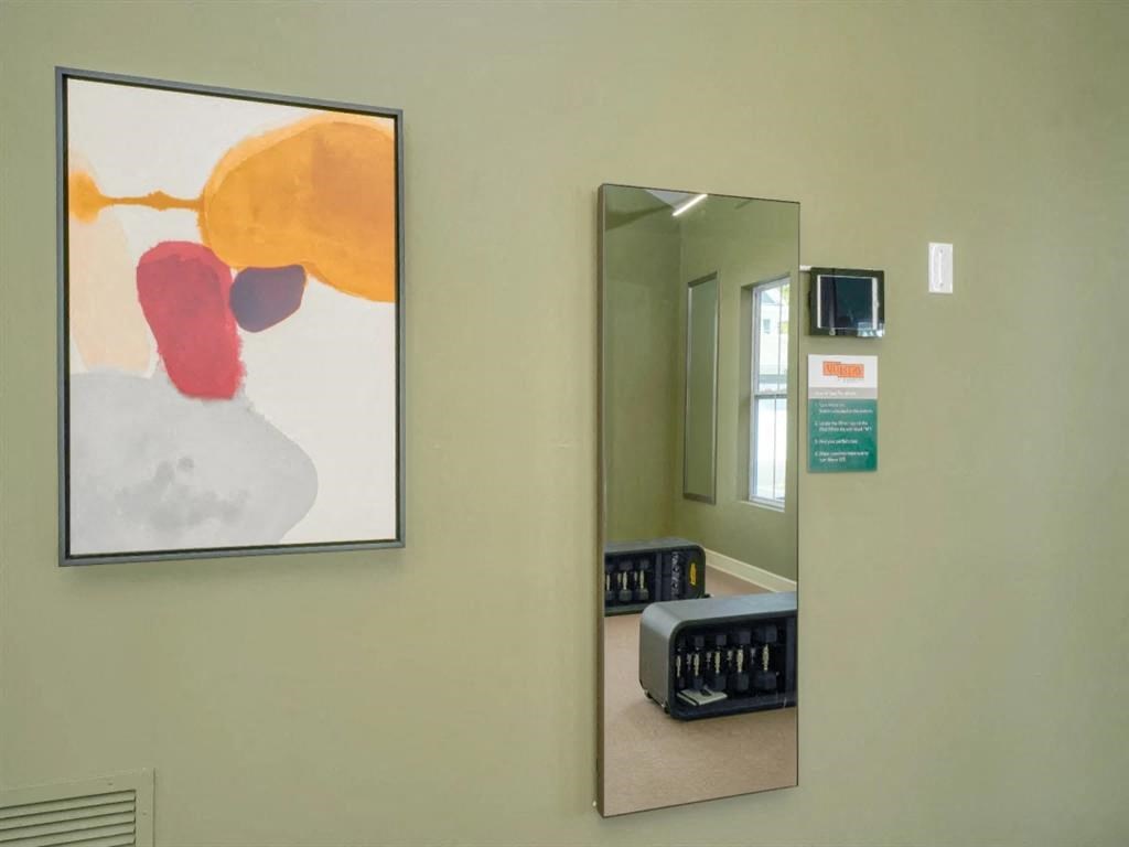a painting hangs on a wall next to a mirror at Artistry at Winterfield Apartments, Midlothian, Virginia