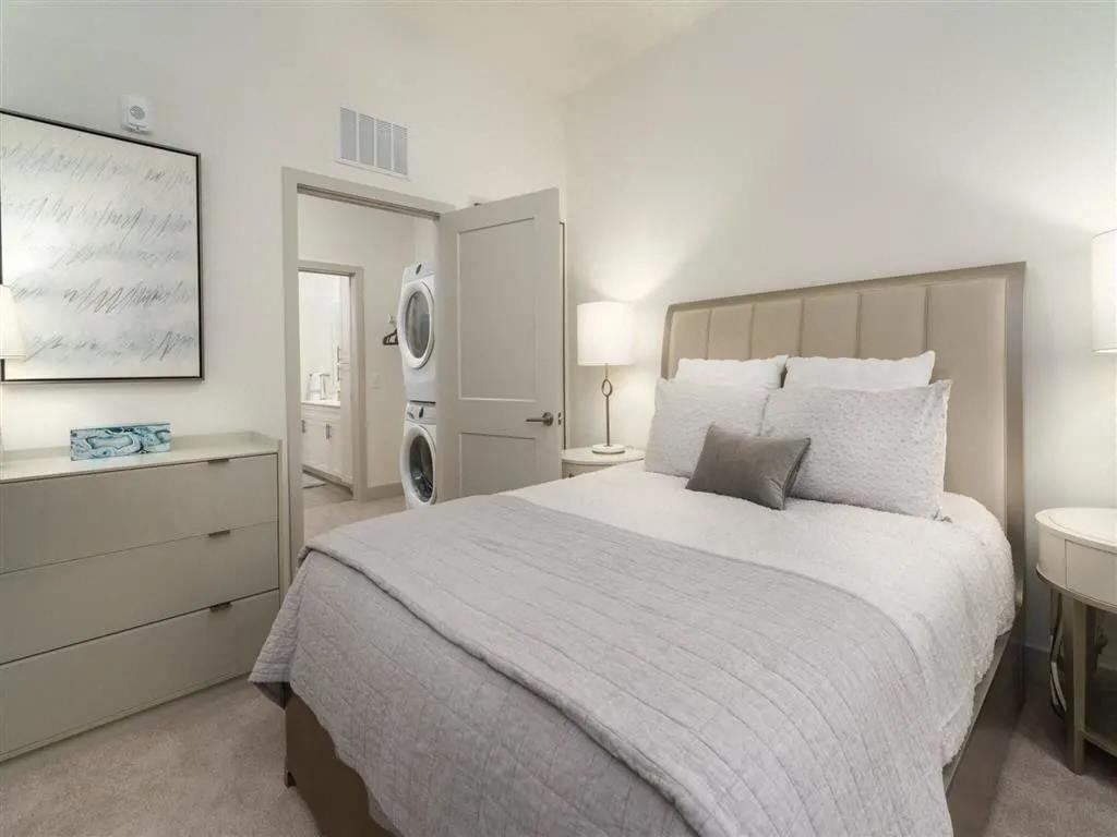 a bedroom with a bed and a washer and dryer at Artistry at Winterfield Apartments, Midlothian, VA, 23112