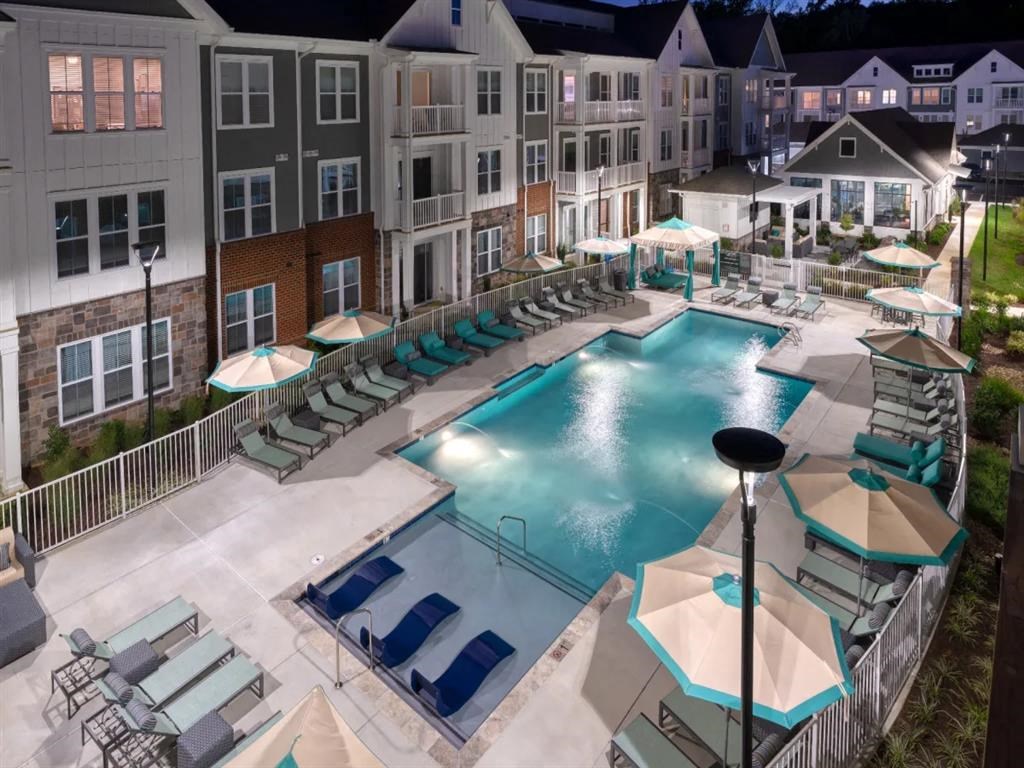 an aerial view of a resort style pool with lounge chairs and umbrellas at Artistry at Winterfield Apartments, Midlothian, VA
