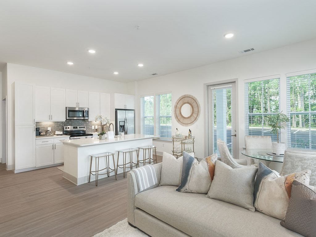 a living room with a couch and a kitchen in the background at Artistry at Winterfield Apartments, Virginia,23112