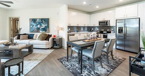 a living room and kitchen with a table and chairs
