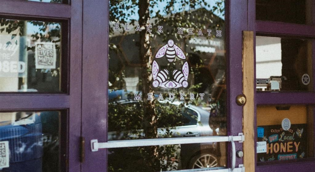 a purple door with a window that has a drawing of a bee on it