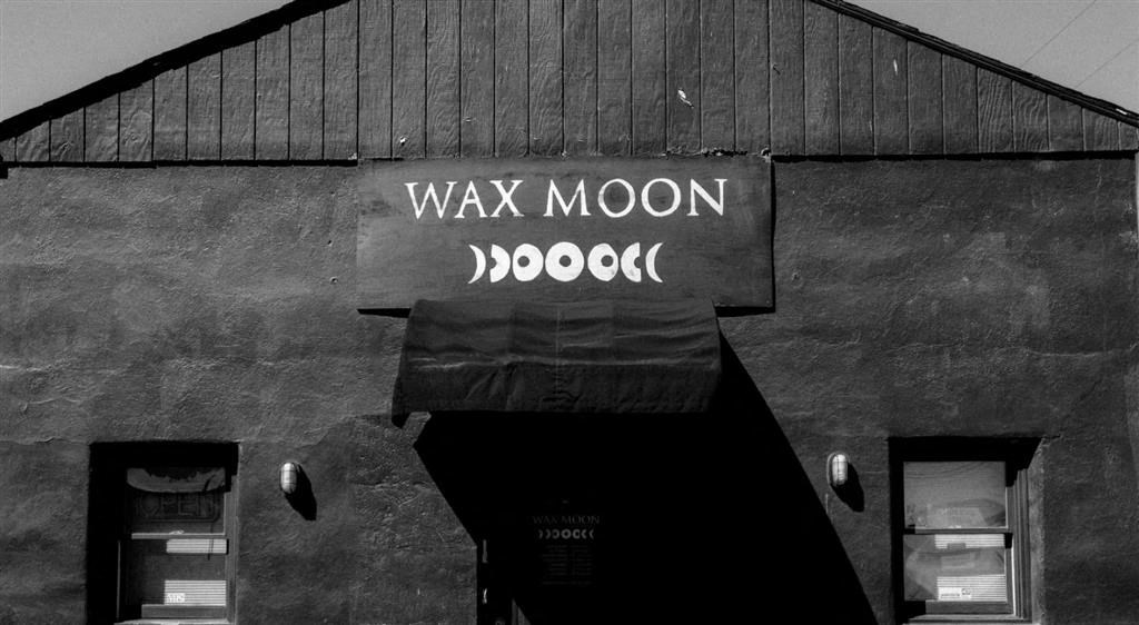 a black and white photo of a building with a sign on it