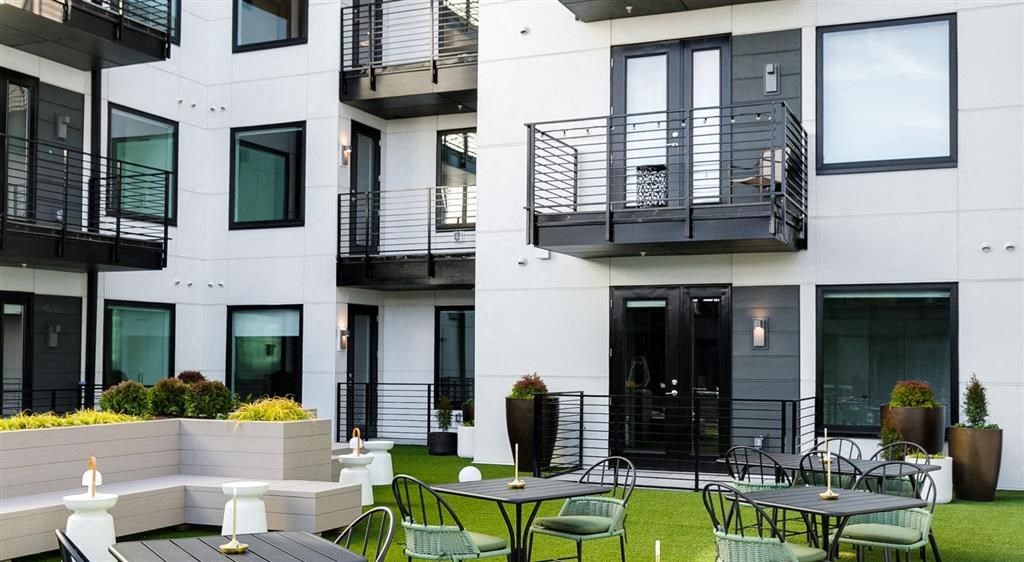 a patio with tables and chairs in front of a building