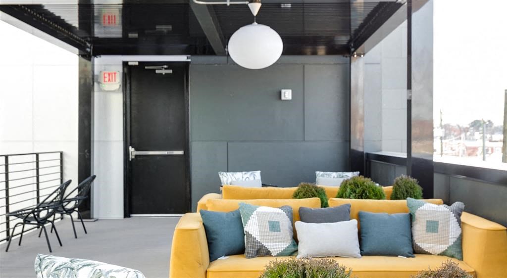 a living room with a yellow couch and blue and white pillows