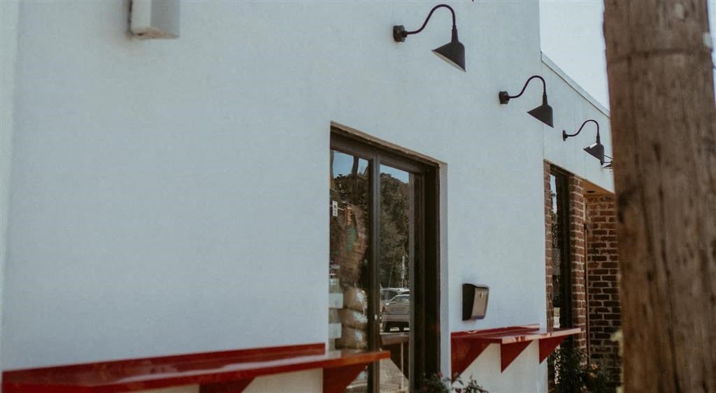 a white building with a glass door and a red bench