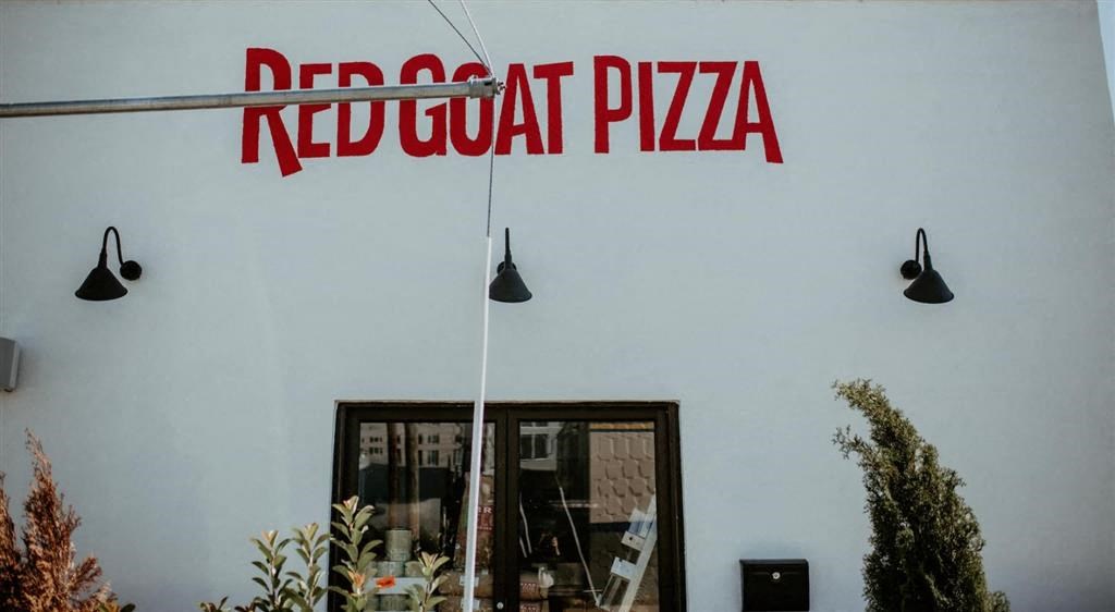 a sign on a wall that reads red goat pizza