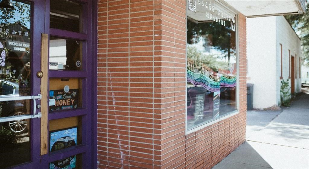 a brick building with a purple door and a window