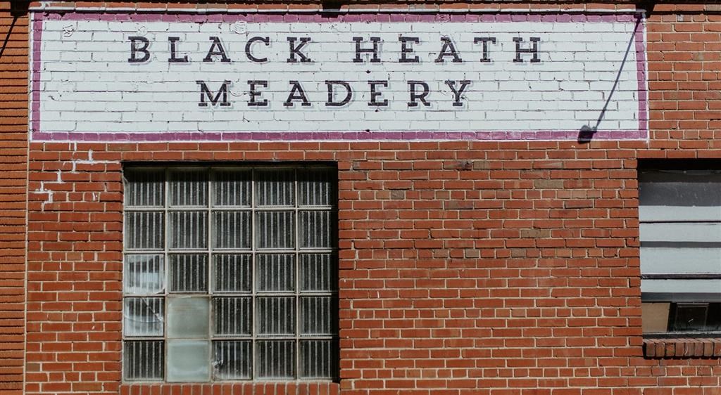 a brick building with a sign that says black hearted merchandise
