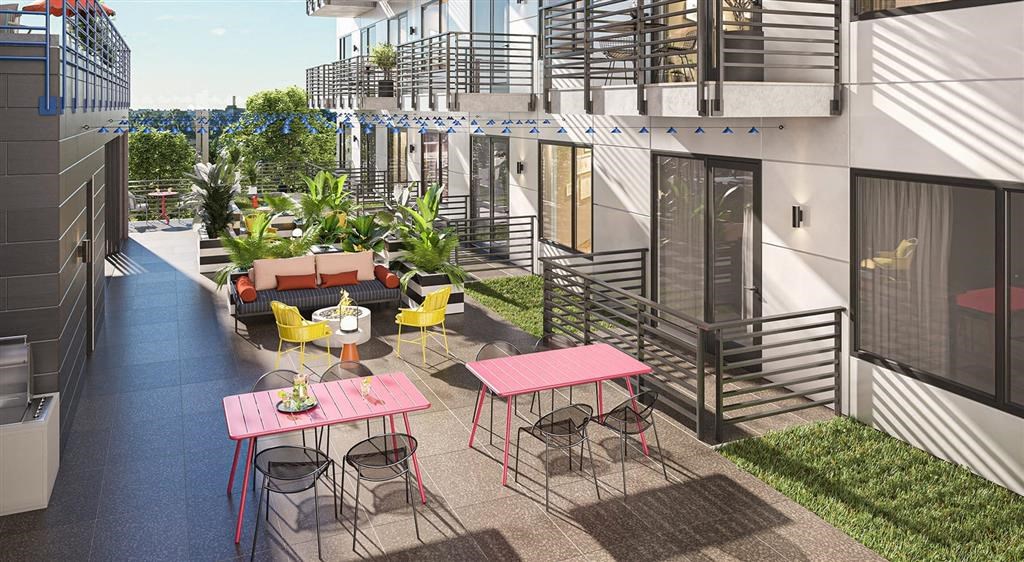 a patio with tables and chairs in front of a building