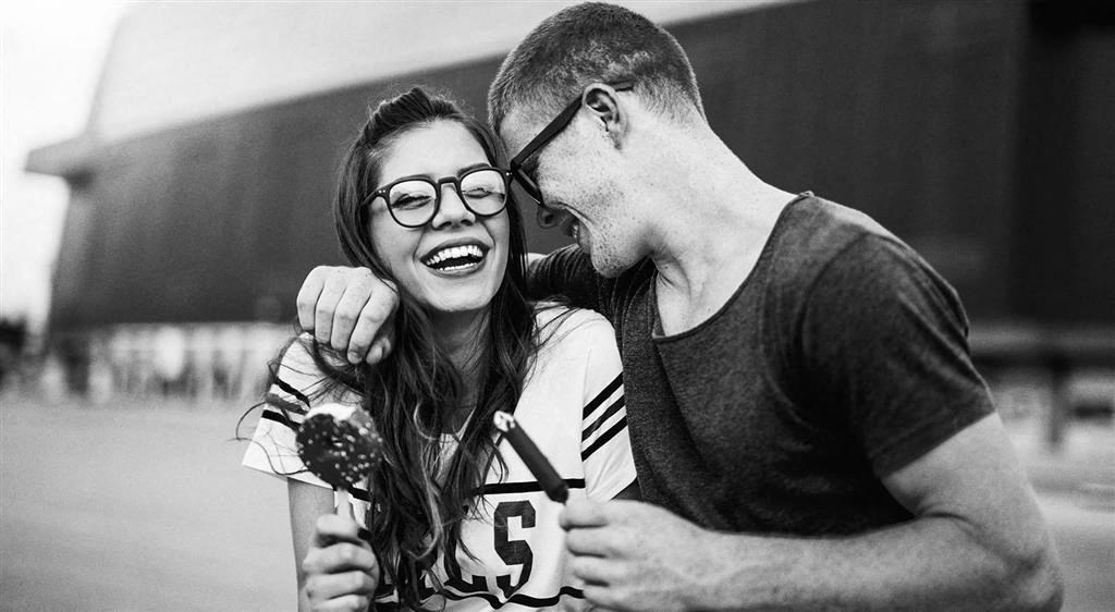 a black and white photo of a man and woman with their arms around each other