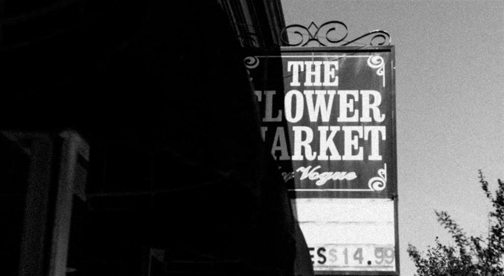 a black and white photo of a sign for the flower market
