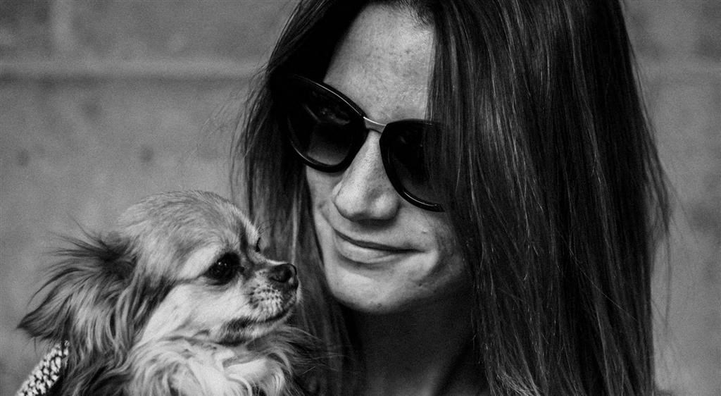 a woman holding a small dog in her arms