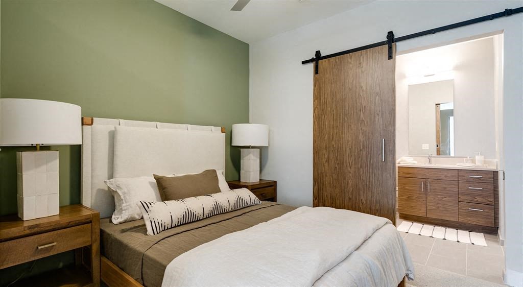 a bedroom with a bed and a bathroom with a sink