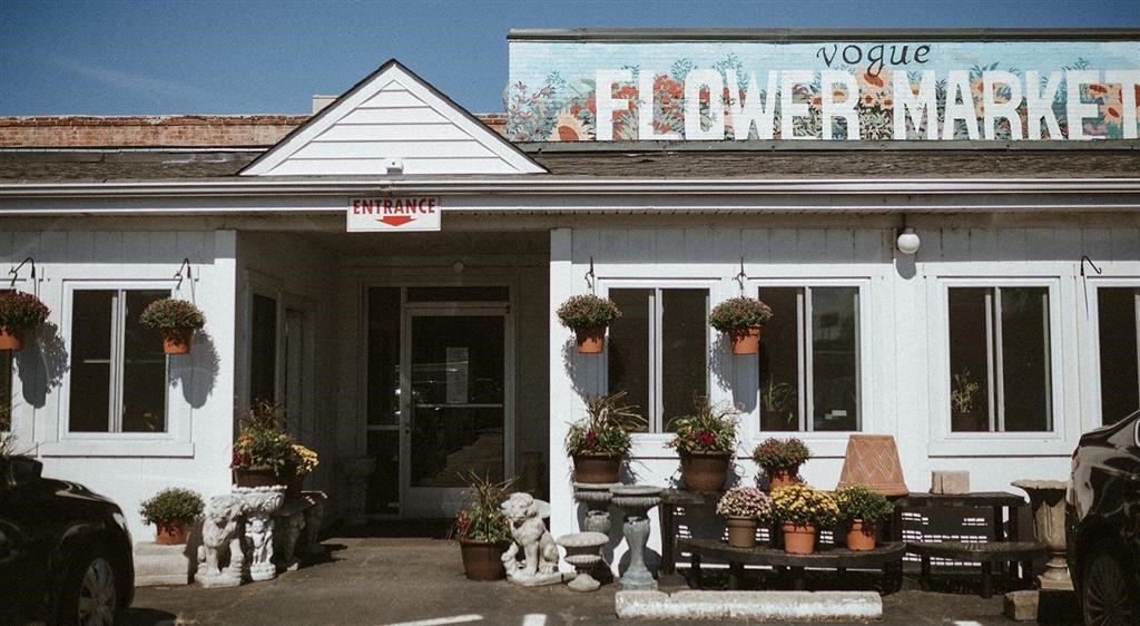 a white building with a sign that reads vogue flower market
