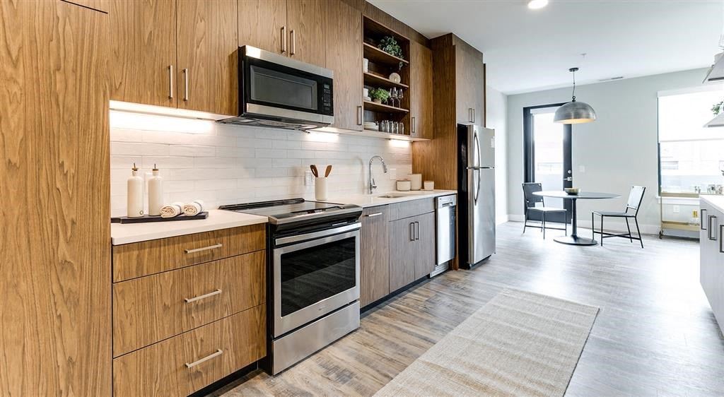 a kitchen with a stove top oven next to a microwave