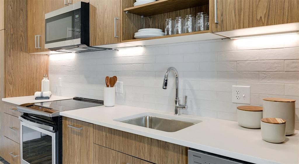 a kitchen with a sink a stove and a microwave