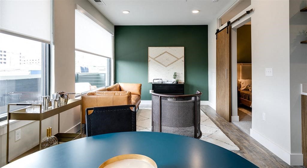 a room with a table and chairs and a couch in the background