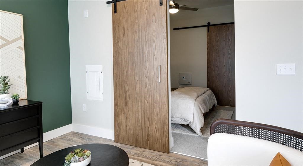 a bedroom with a bed in the background and a table and chair in the foreground