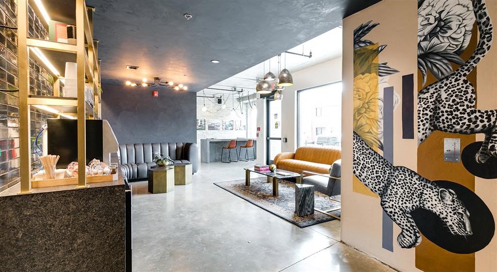 a lobby with a yellow couch and a giraffe on the wall