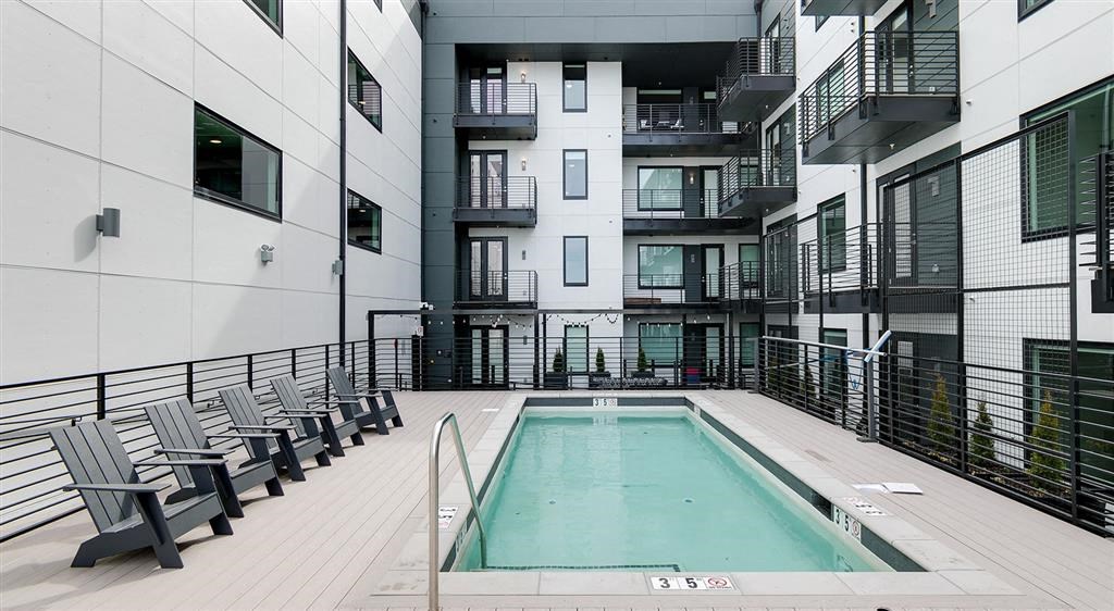 a pool is shown in front of an apartment building
