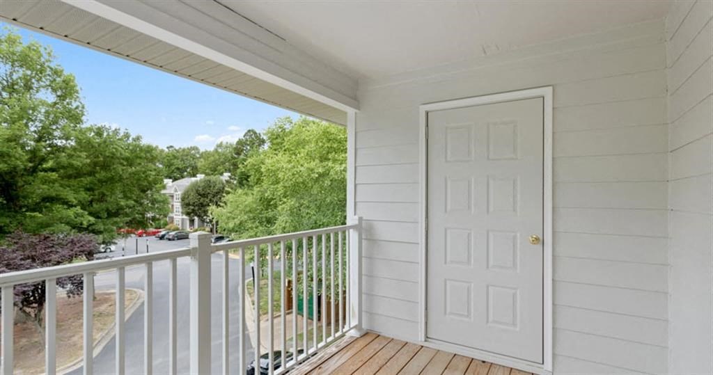 a white door opens to a balcony with a street in the background at Trails at Short Pump Apartments, Richmond