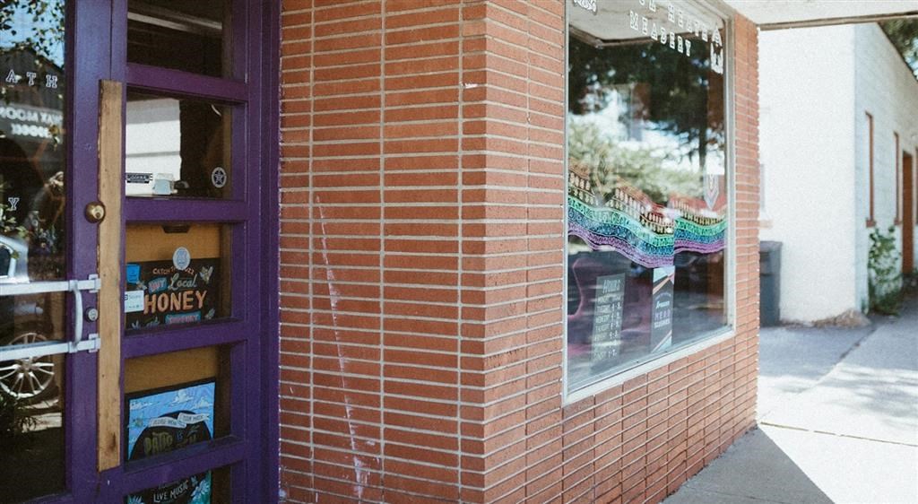 a brick building with a purple door and a window