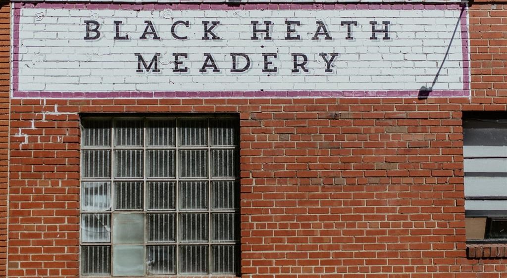 a brick building with a window and a sign that reads black heat meader