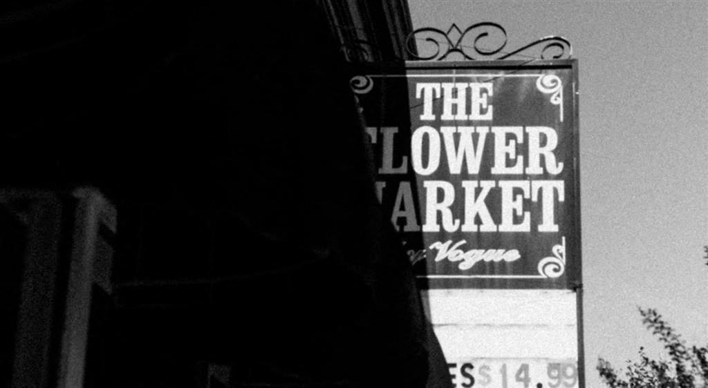 a black and white photo of a sign for the flower market