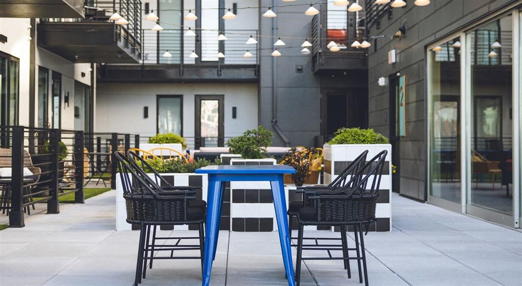 an outdoor patio with a blue table and black chairs